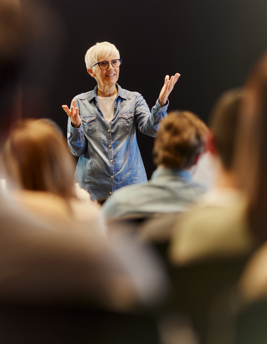 Frau hält Vortrag vor Publikum.